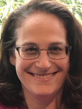 Picture of Nina, a woman wearing glasses.