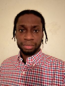 Picture of Arturito, an Afro Hispanic is a male with brown eyes, black hair, facial hair wearing a red button down shirt.