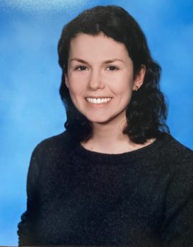 Picture of Kristen, a white woman with short brown hair and brown eyes. She is wearing a dark grey sweater and dolphin earrings.