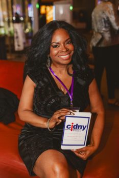 Gala attendee seated holding a CIDNY brochure.