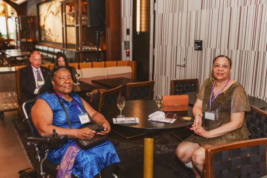 Gala attendees seated speaking to each other.