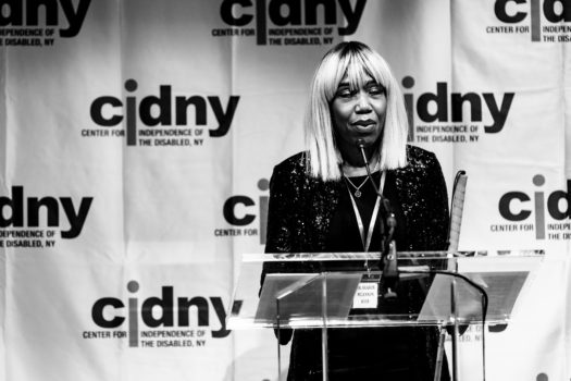 CIDNY's Dr. Sharon McLennon Wier speaking at a podium.