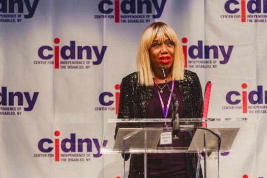 CIDNY's Dr. Sharon McLennon Wier speaking at a podium.