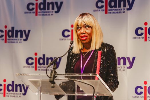 CIDNY's Dr. Sharon McLennon Wier speaking at a podium.