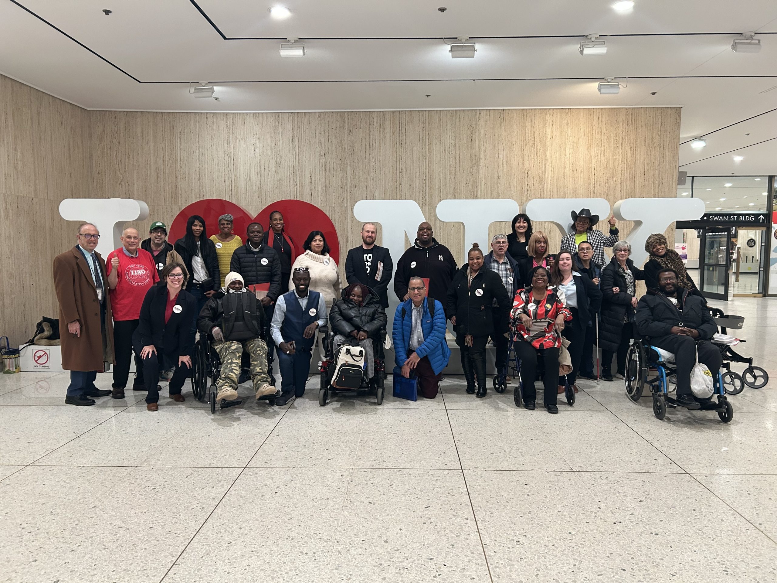 A group of advocates stand in from of an I Love New York sign during CIDNY's 2025 Lobby Day in Albany.