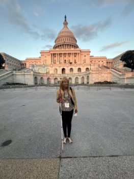 CIDNY's Dr. Sharon McLennon Wier, holding a white cane, standing in front of the Capitol building in Washington D.C.