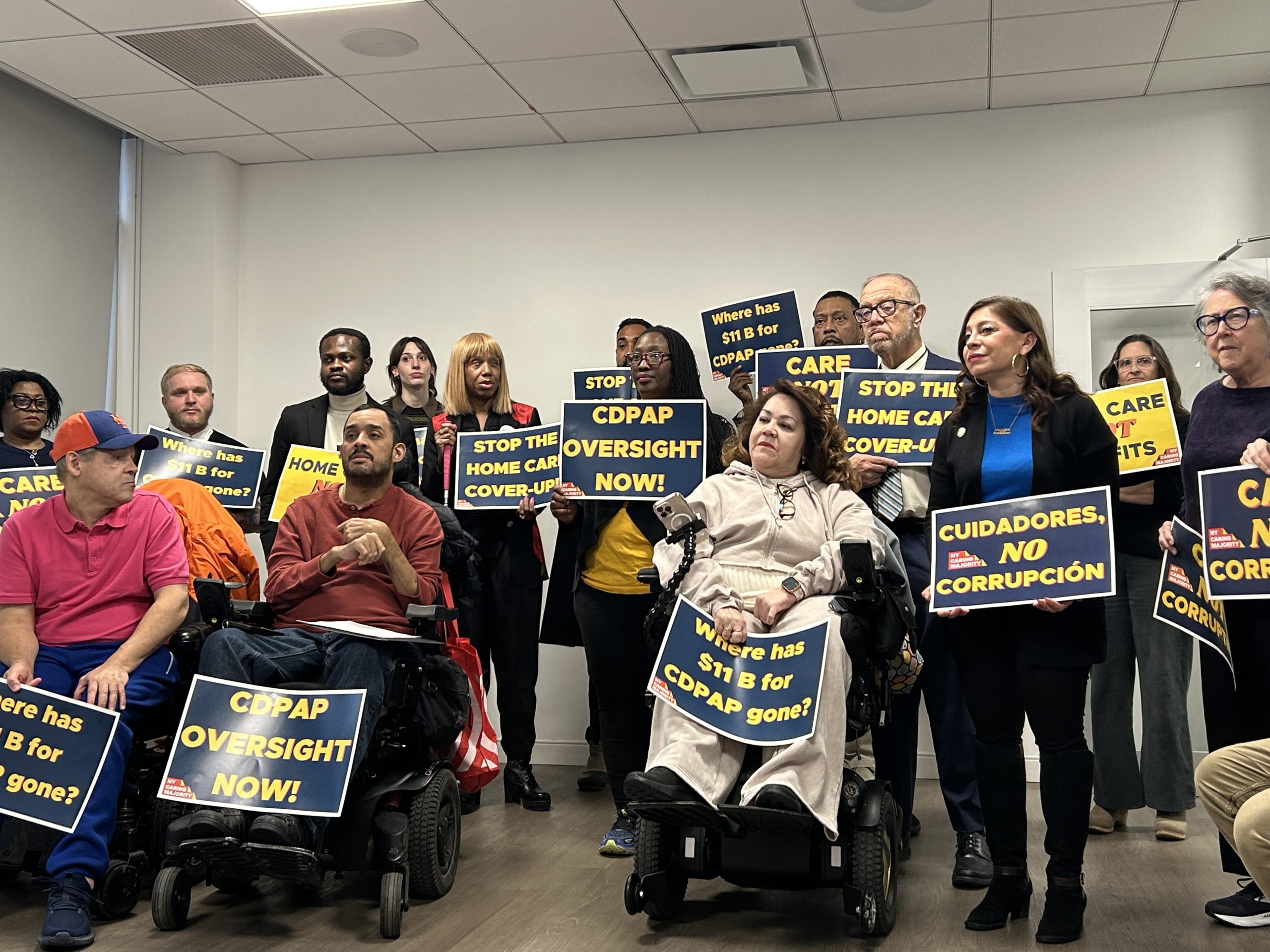 A group of adovcates gatherd in CIDNY Manhattan office holding CDPAP-related signs for a press conference about the Consumer Directed Personal Assistance Program.