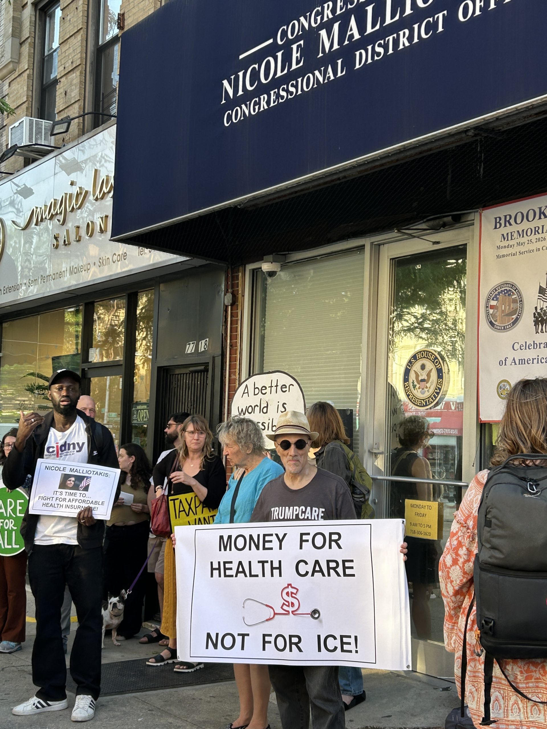 CIDNY staff with advocates outside local electeds office with advocates holding signs calling for health care funding.